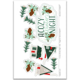 Die-cut ephemera sheet from the Cozy Winter's Night Scrapbook Page Kit by Miss Kate Designs featuring pinecones, trees, cabins, and a cozy winter title. Perfect for embellishing 12x12 winter-themed scrapbook layouts and DIY crafting projects